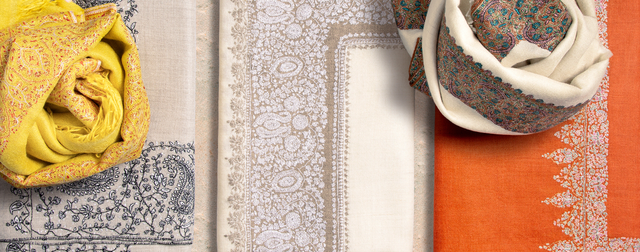 Pashmina shawls in sunny shades of yellow, cream and orange with hand embroidered borders.