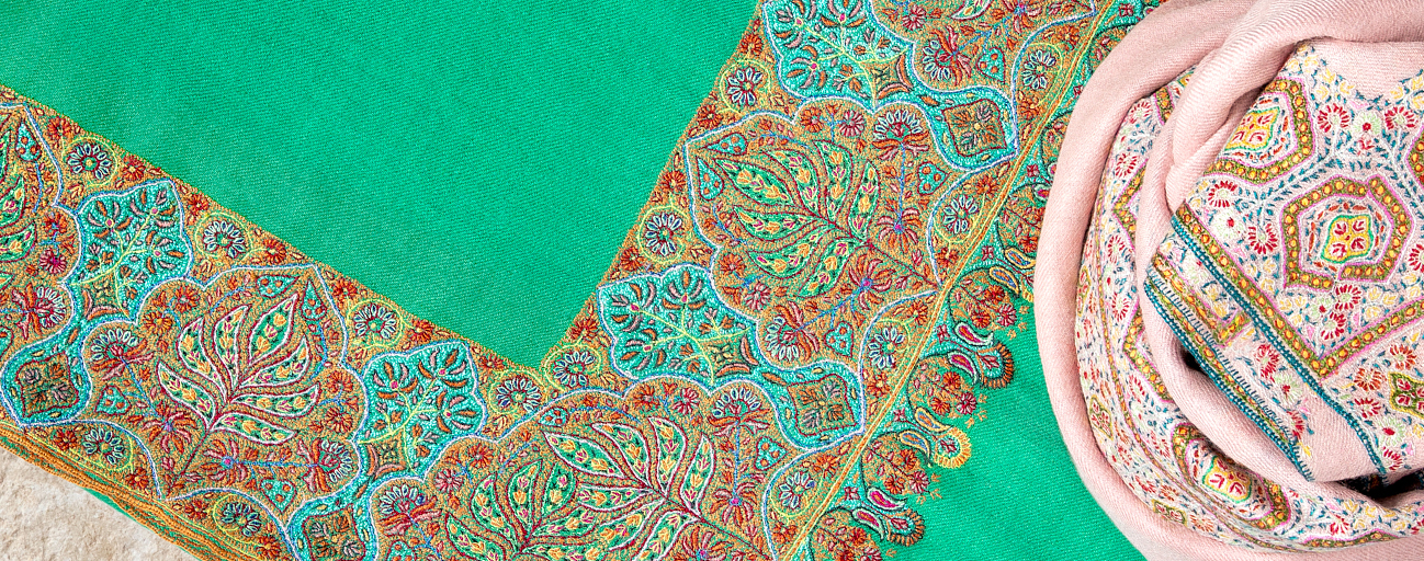 Jade green and pale pink pashmina shawls with complex hand embroidered borders.
