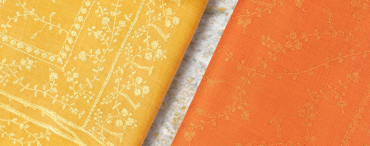 Two pashmina shawls in shades of orange and yellow with hand embroidery all over.